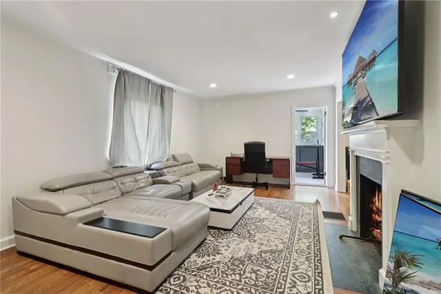 a living room with furniture a fireplace and a flat screen tv