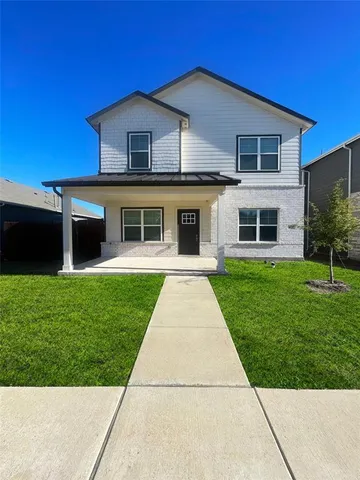 a front view of a house with a yard and potted plants