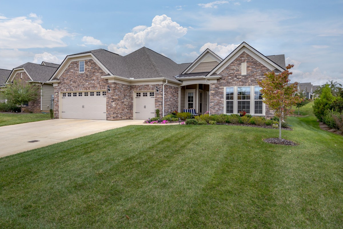 a front view of a house with a yard and trees