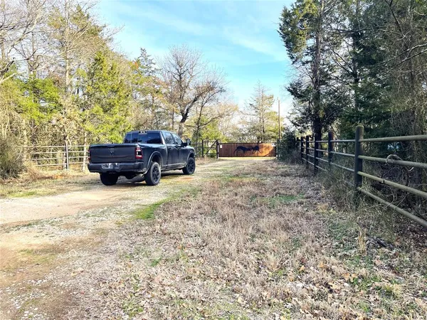 a view of a backyard with wooden fence and a bench