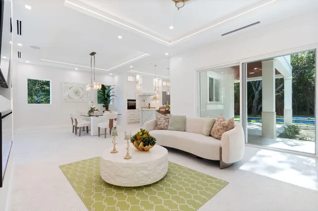 a view of a dining room and livingroom with furniture wooden floor a potted plant and a chandelier
