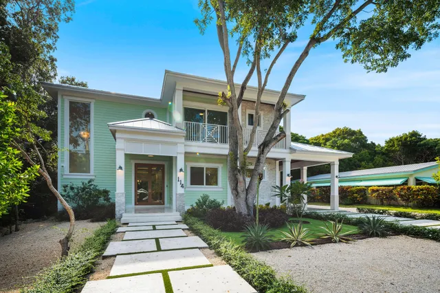 a front view of a house with a yard and potted plants