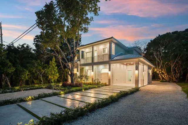 a view of a house with large trees and a big yard