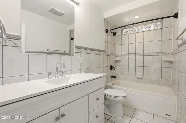 a bathroom with a bathtub shower sink vanity and toilet