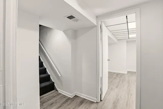 a view of entryway and hall with wooden floor