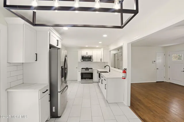 a kitchen with a sink stainless steel appliances a refrigerator and cabinets