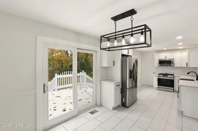 a kitchen with stainless steel appliances kitchen island granite countertop a refrigerator and a stove top oven