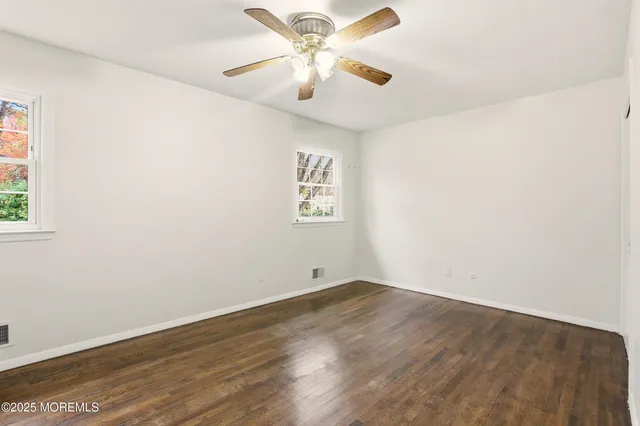 an empty room with a window and a fan