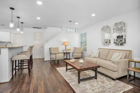 a living room with furniture and wooden floor