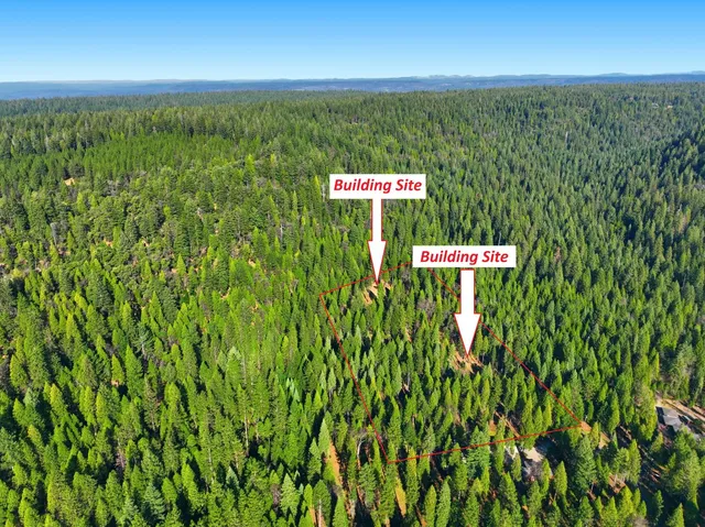 a sign that is sitting in the grass next to a building