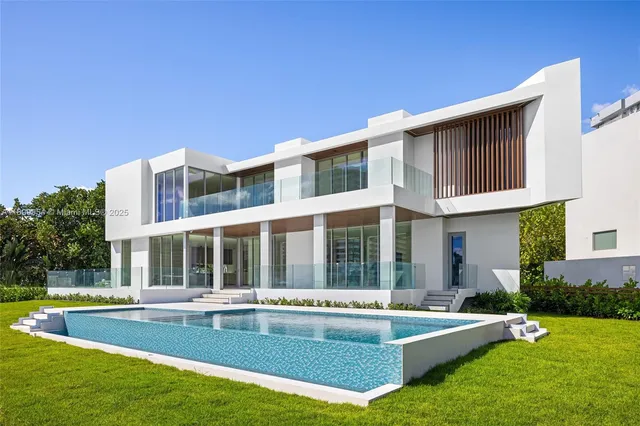 a view of a house with a backyard patio and swimming pool