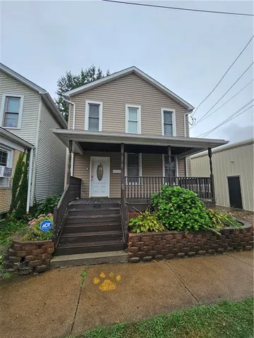 a front view of a house with a garden