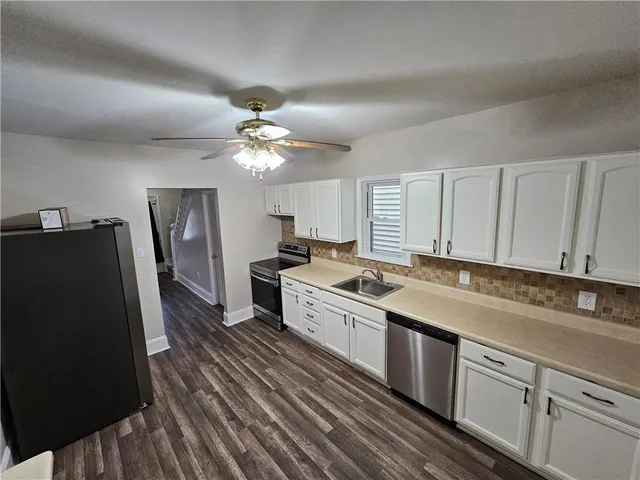a kitchen with a sink dishwasher a refrigerator and cabinets