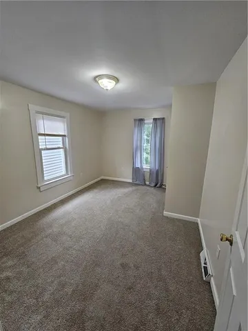 an empty room with windows and closet