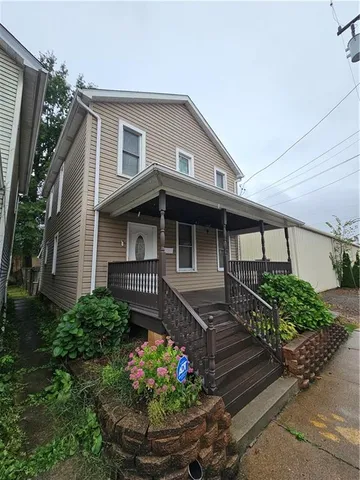 a front view of a house with a yard and potted plants