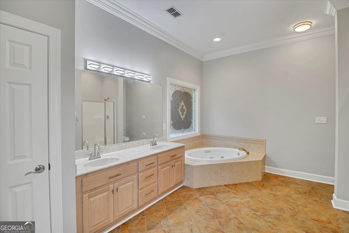 396 Meander Trace Thomasville, GA 31792 - Photo 18 of 50 a bathroom with a double vanity sink a mirror and bathtub