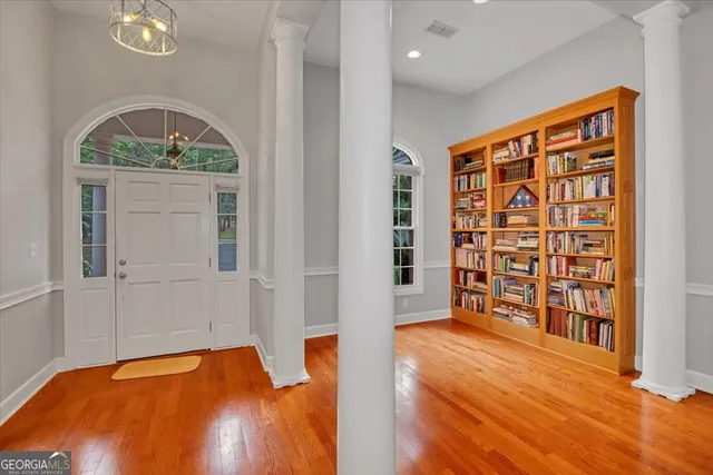 a view of a book shelf with windows in a room