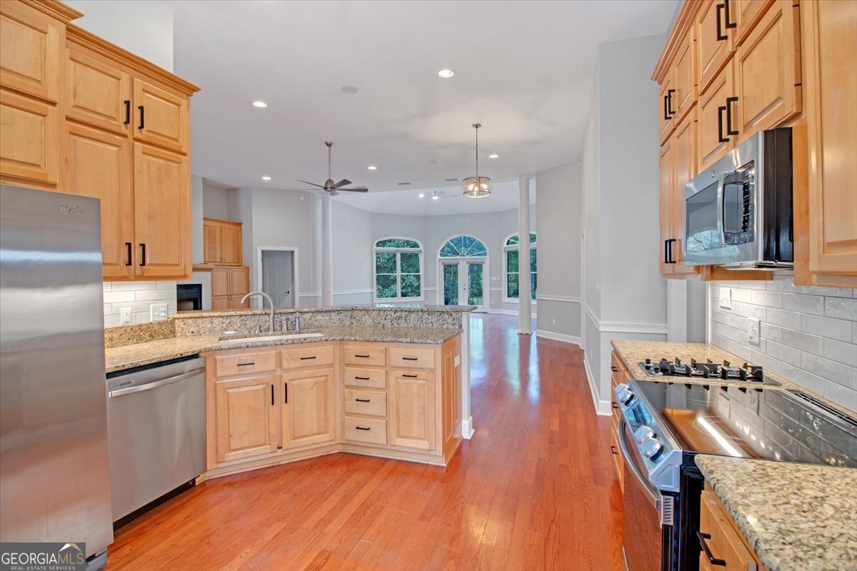 396 Meander Trace Thomasville, GA 31792 - Photo 8 of 50 a large kitchen with stainless steel appliances granite countertop a lot of counter space and wooden floors