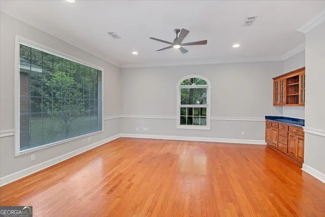 a view of an empty room with a window and wooden floor