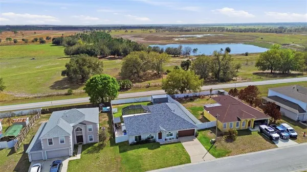 an aerial view of residential houses with outdoor space and ocean view