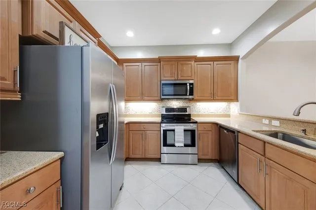 a kitchen with stainless steel appliances granite countertop a refrigerator sink and stove