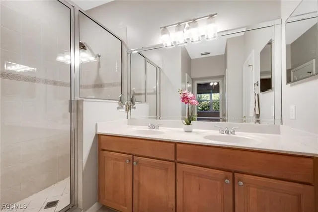 a bathroom with a double vanity sink mirror and shower