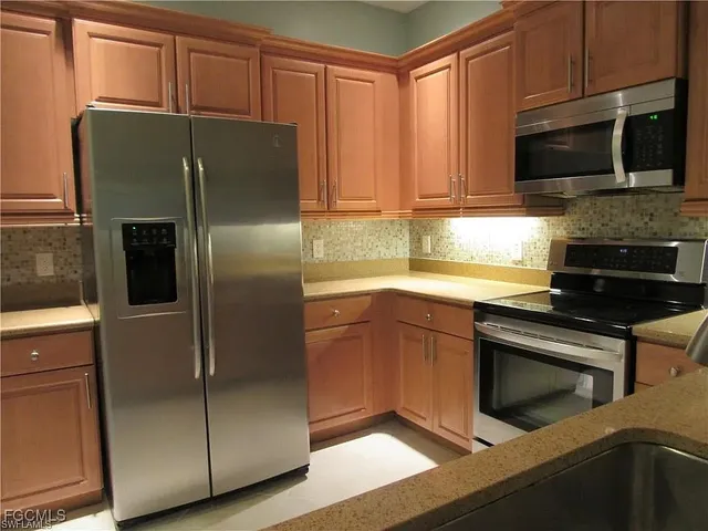 a kitchen with granite countertop stainless steel appliances and wooden cabinets