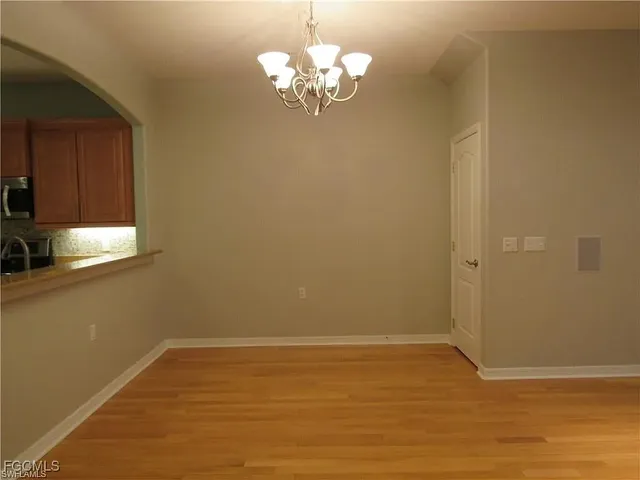 a view of a room with wooden floor and chandelier