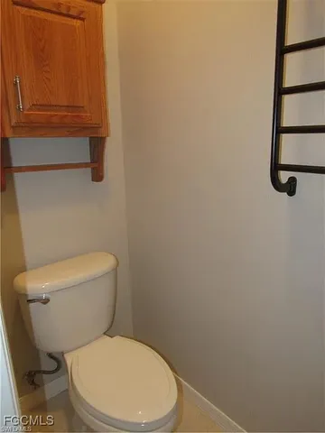 a white toilet sitting next to a shower