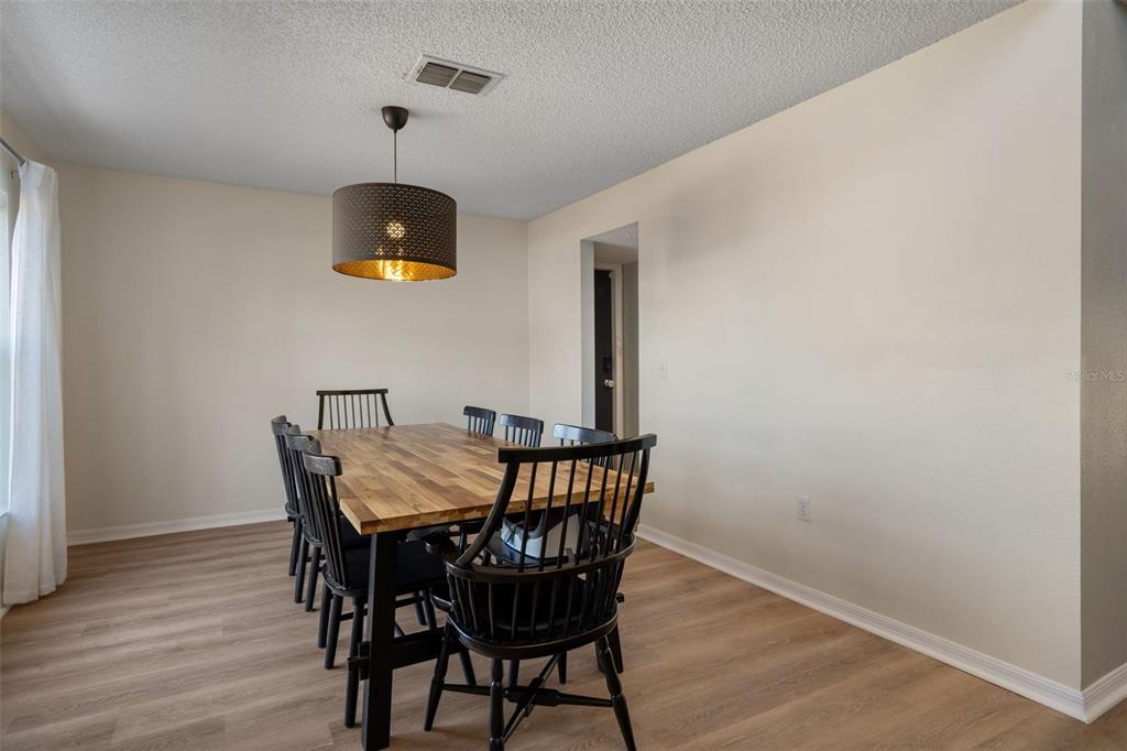 11258 Lomita Wren Road Weeki Wachee, FL 34614 - Photo 6 of 44 a view of a dining room with furniture and wooden floor