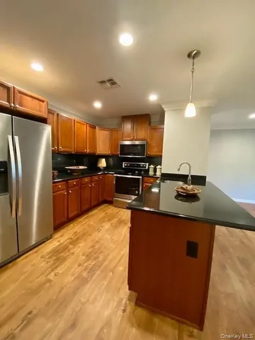 a kitchen with stainless steel appliances granite countertop a sink a stove and a refrigerator