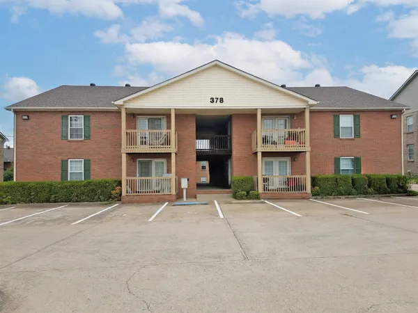 front view of a brick house with a yard