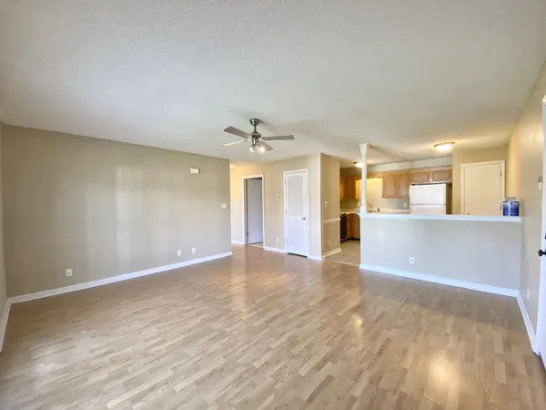 a view of an empty room and kitchen view