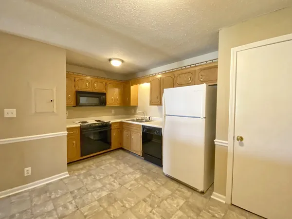 a kitchen with a refrigerator a stove top oven and a sink