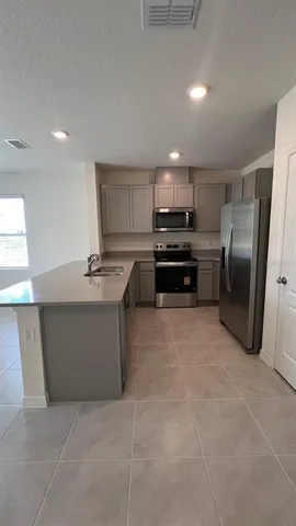 a kitchen with stainless steel appliances a refrigerator sink and stove