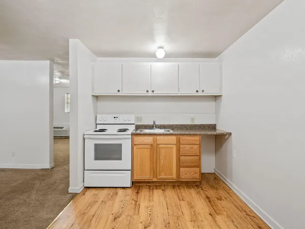 a kitchen with stainless steel appliances granite countertop a stove and white cabinets