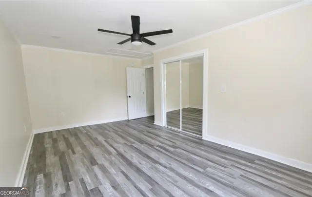 an empty room with wooden floor and windows