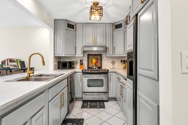 a kitchen with stainless steel appliances granite countertop a sink stove and refrigerator