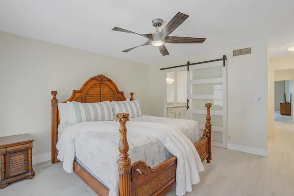 a bed room with a bed and a ceiling fan