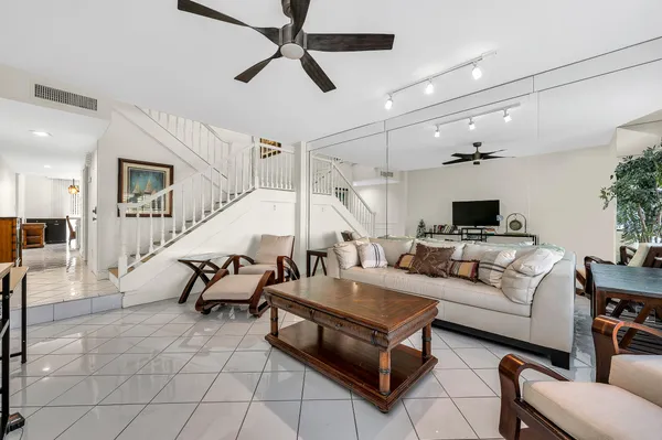 a living room with furniture and a ceiling fan