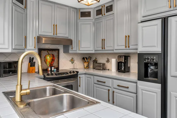 a kitchen with granite countertop a sink stainless steel appliances and cabinets