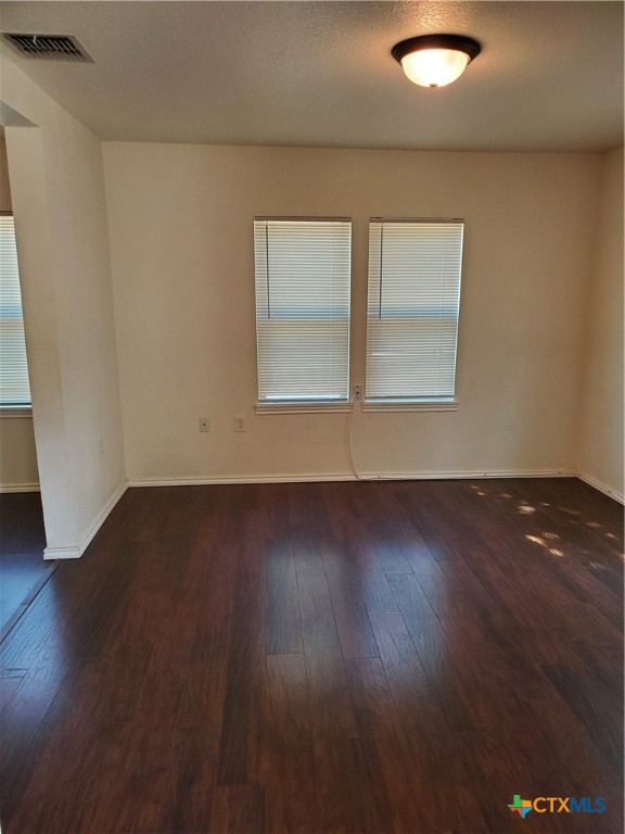 826 North Bowie Street Seguin, TX 78155 - Photo 3 of 9 an empty room with wooden floor and windows