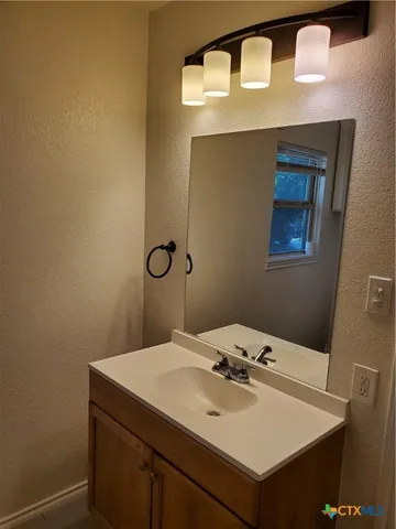 a bathroom with a sink vanity and a mirror