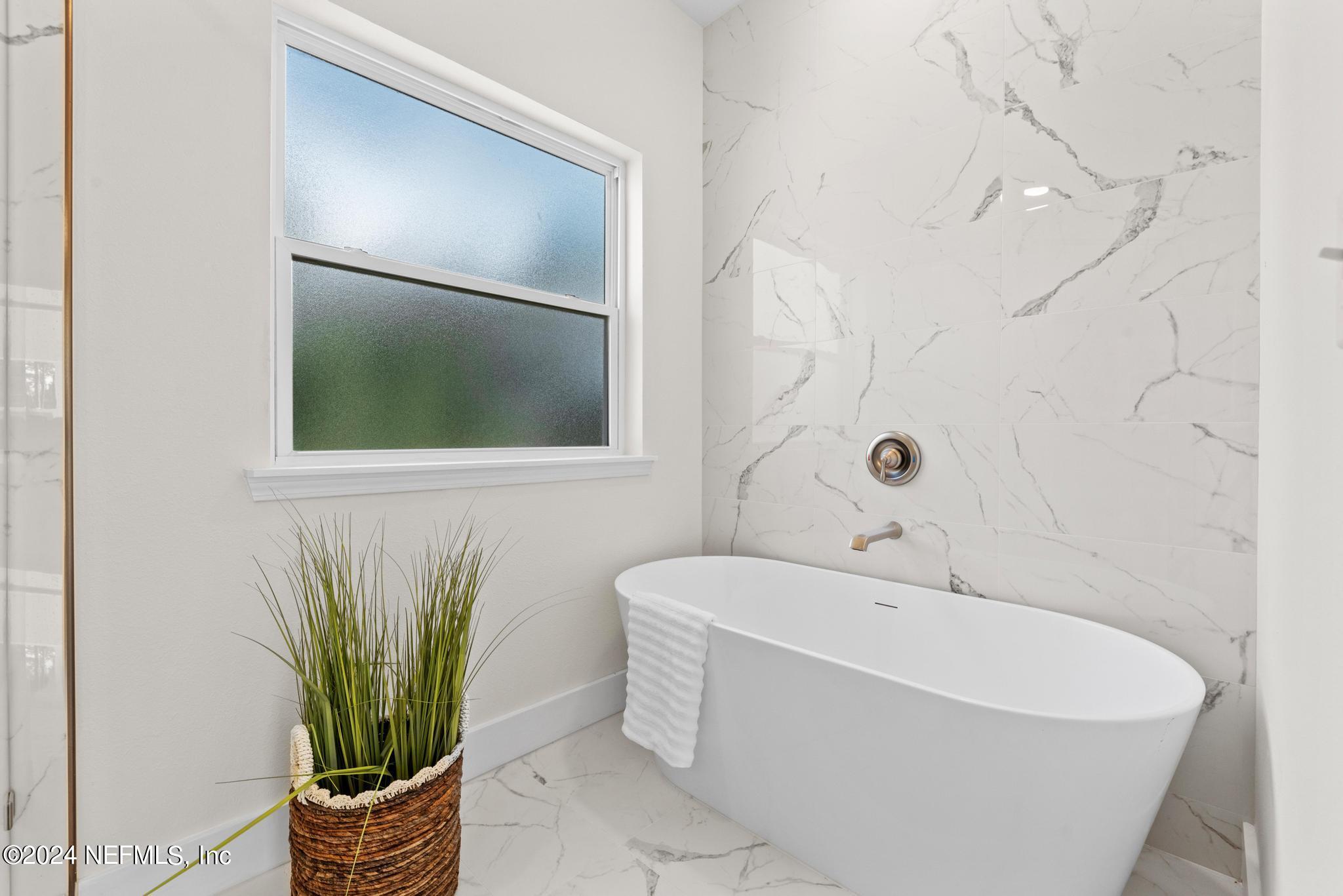 12731 Old St Augustine Road Jacksonville, FL 32258 - Photo 17 of 24 a white bath tub sitting in a bathroom
