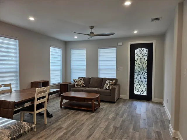 a living room with furniture and a wooden floor