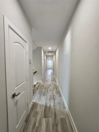 a view of a hallway with wooden floor