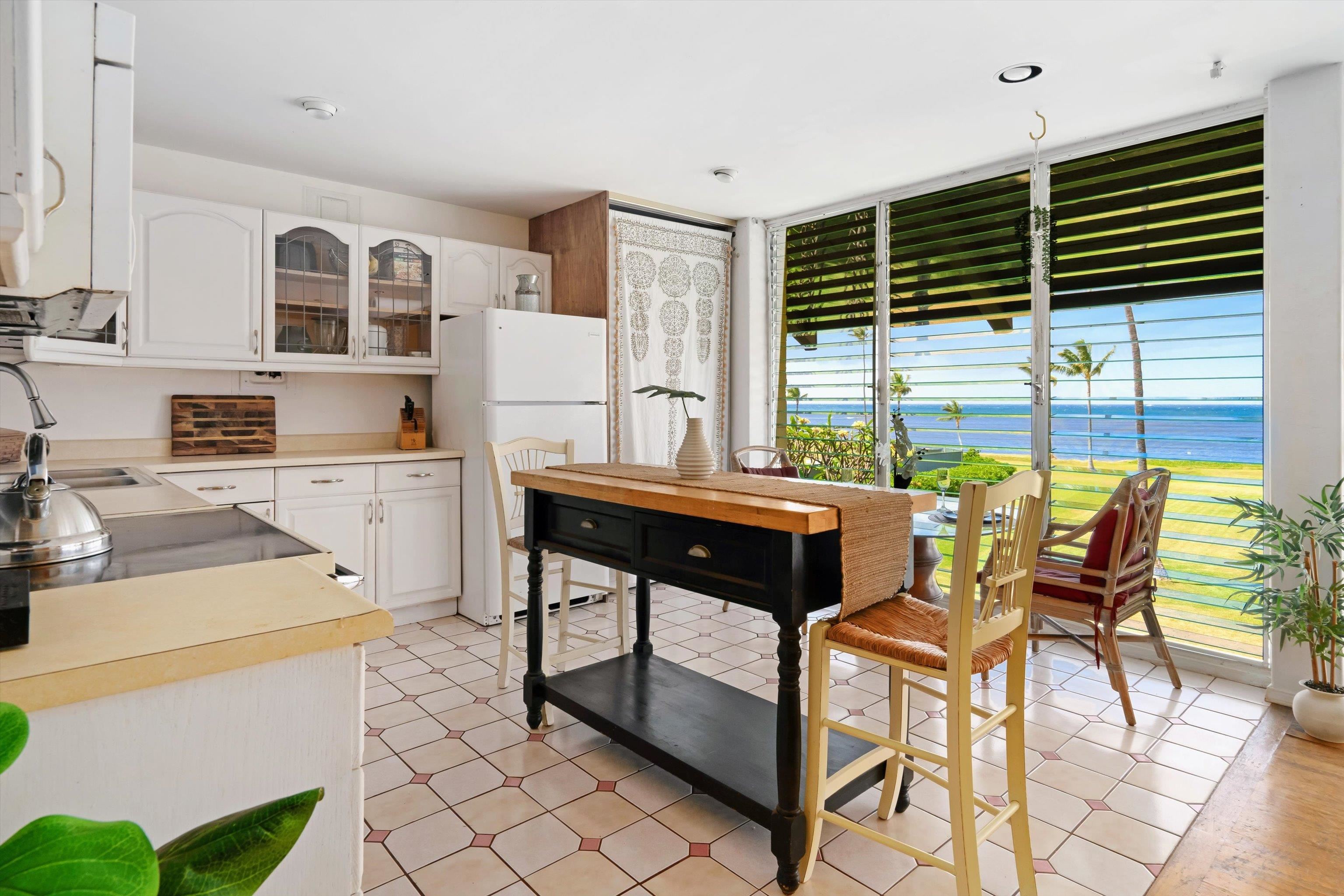 1002 South Kihei Road, Unit 314 Kihei, HI 96753 - Photo 9 of 31 a kitchen with a table chairs and a refrigerator