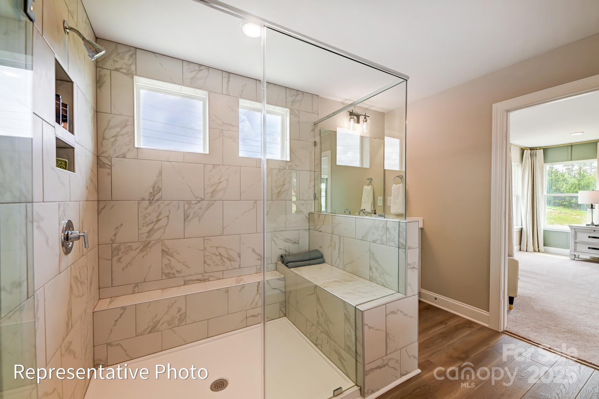 5038 Mclaughlin Loop Waxhaw, NC 28173 - Photo 18 of 25 a bathroom with a granite countertop sink a mirror and shower