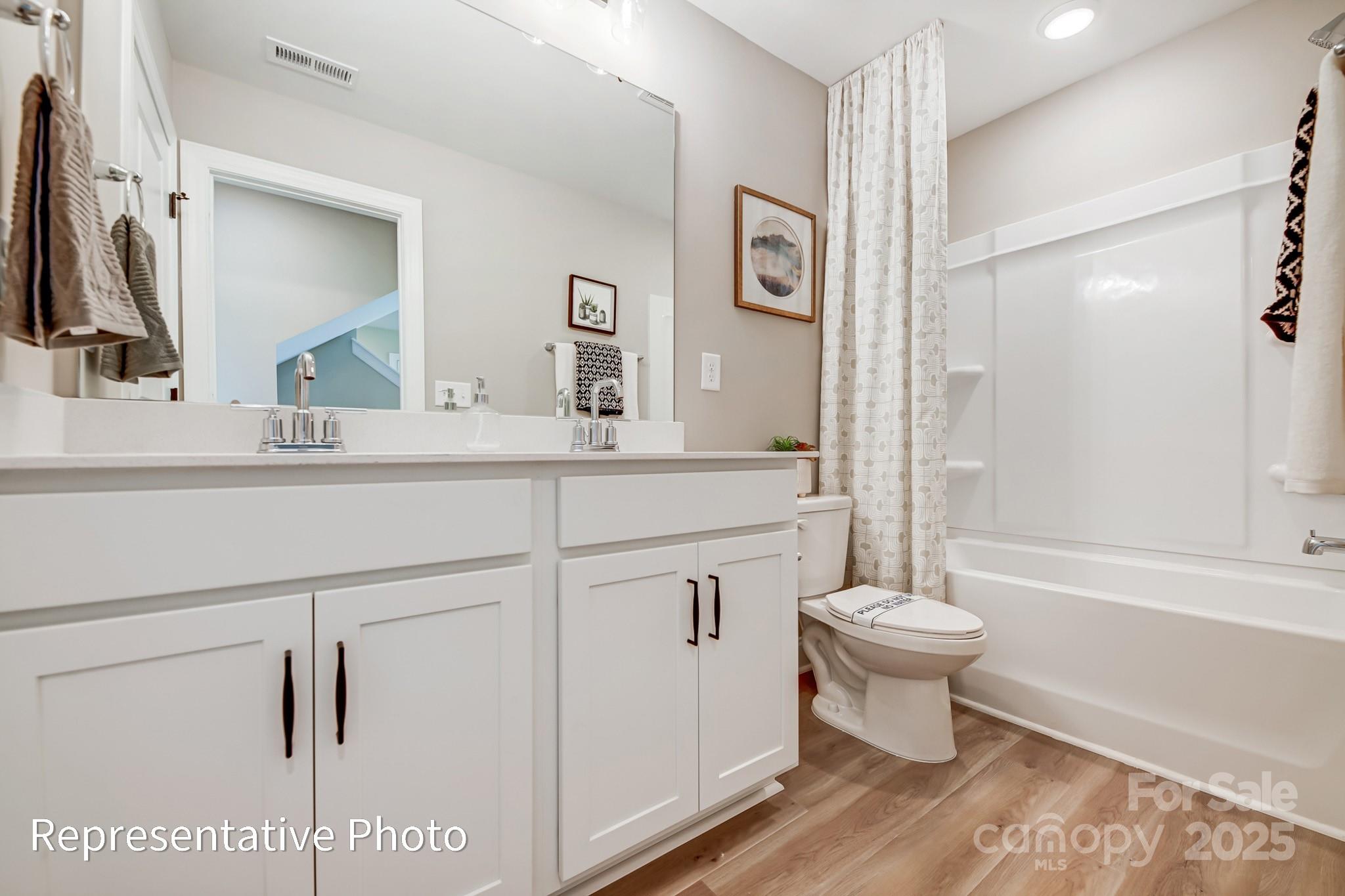 5038 Mclaughlin Loop Waxhaw, NC 28173 - Photo 21 of 25 a bathroom with a toilet a sink a mirror a bathtub and shower