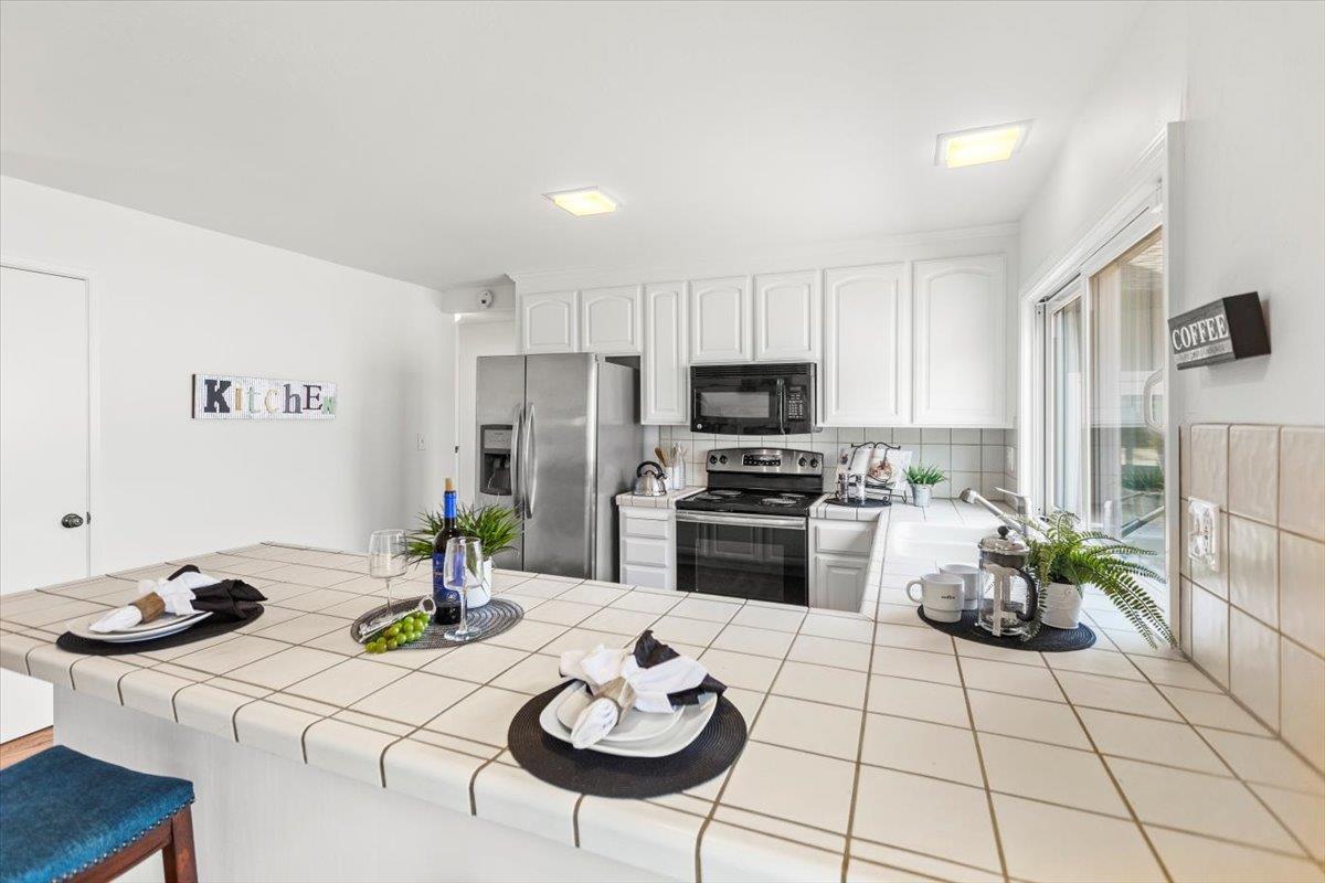 4155 Keith Drive San Jose, CA 95008 - Photo 10 of 28 a kitchen with stainless steel appliances kitchen island granite countertop a sink a stove a dining table and chairs with wooden floor